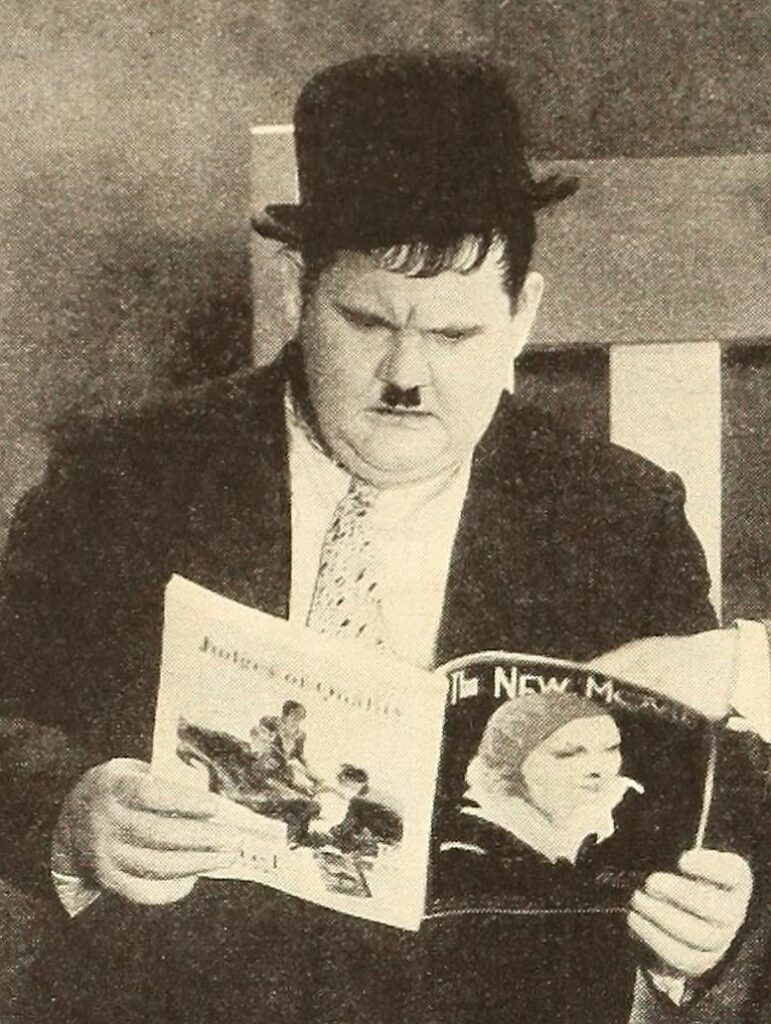 Photograph of actor Oliver Hardy reading an issue of 'The New Movie' magazine. He wears a jacket and bowler hat.||Hardy was a successful character actor in silent films and a partner in the Academy Award-winning comedy team of Laurel and Hardy. Born and raised in Georgia, Hardy performed in theater and vaudeville shows around the state early in his career, which laid the foundation for his later success as a film comedian.