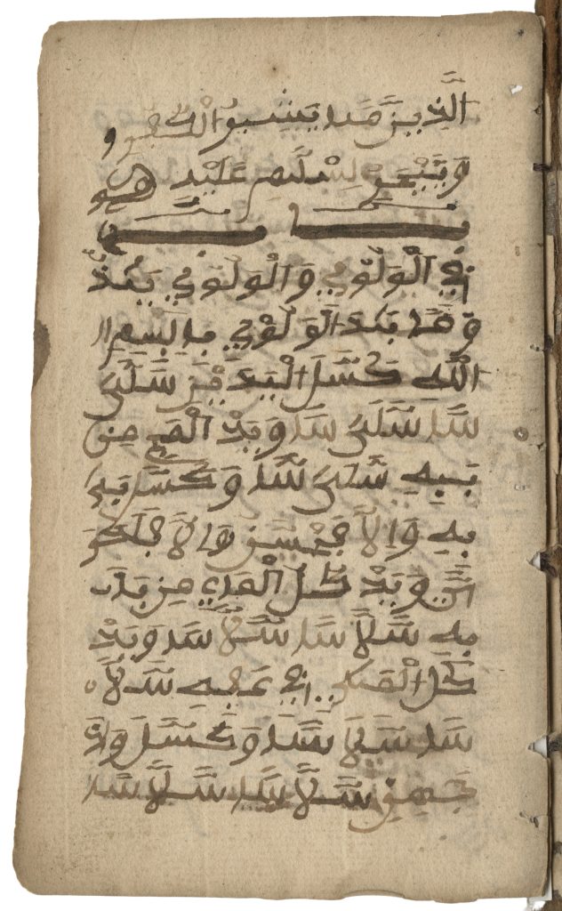 Color image of a page from the Bilali Manuscript composed by Bilali Mohammed, an enslaved African on Sapelo Island. Arabic script fills the page and the book's spine is visible on the righthand side.