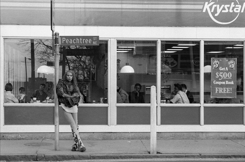 A young RuPaul leans against a Peachtree Street sign outside of a Krystal restaurant in Atlanta in 1988.