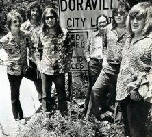 Members of the Atlanta Rhythm Section—(left to right) J.R. Cobb, Ronnie Hammond, Barry Bailey, Paul Goddard, Robert Nix, and Dean Daughtry—stand before a sign indicating the Doraville city limits.