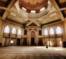 Interior of Al-Farooq Masjid of Atlanta, depicting a detailed carpet, window archways, and a central dome.